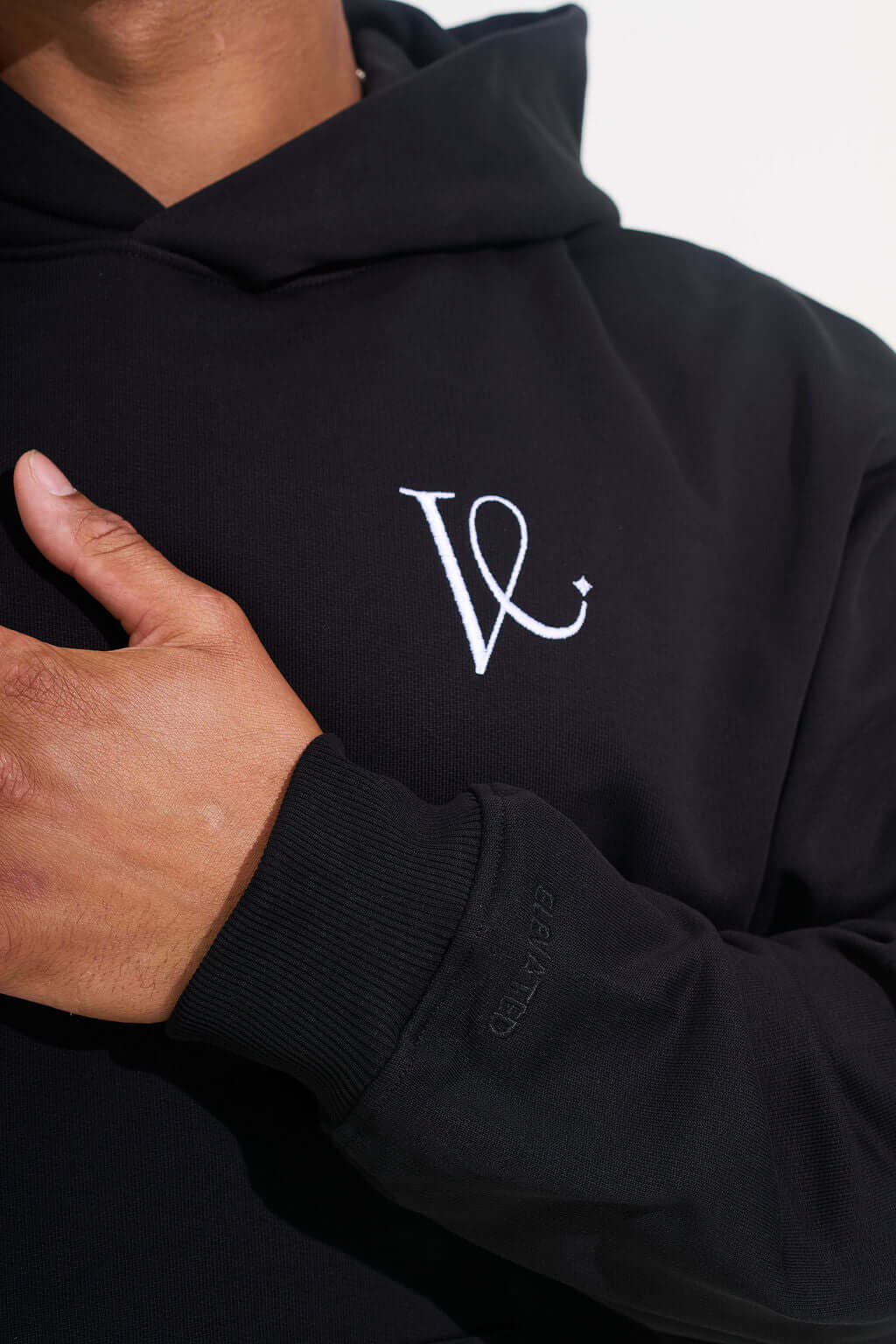 Close-up of the embroidered chest monogram and tone on tone sleeve lettering - KAVEON