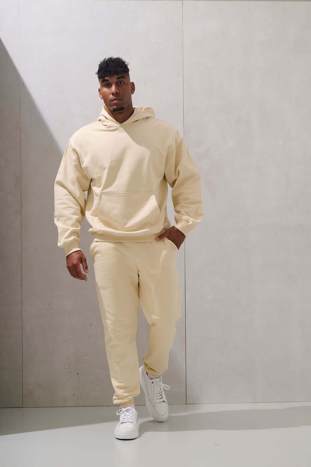 Full length view of the unisex cream hoodie worn as a matching set - KAVEON